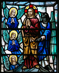 ST. JOHN'S, NEWFOUNDLAND, CANADA- JUNE 26, 2014: The devil trying to temp Jesus in a stained glass window from the Anglican Cathedral of St John the Baptist in St. John's, NFLD.