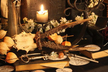 Black candle Magic Ritual. Antique Magic Book. Witchcraft  Peacock feathers and candle background.