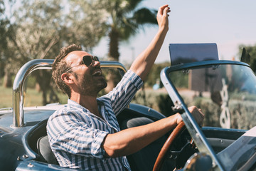 Man driving a convertible vintage car - obrazy, fototapety, plakaty