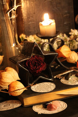 Black candle Magic Ritual. Antique Magic Book. Witchcraft  Peacock feathers and candle background.