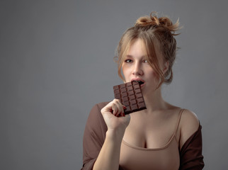 Happy young beautiful woman eating chocolate.