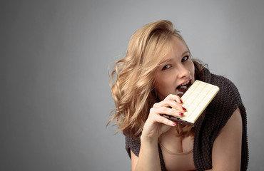 Happy young beautiful woman eating chocolate.