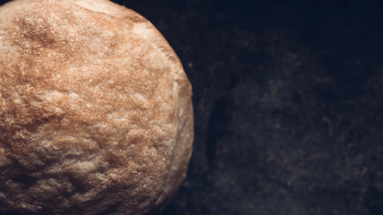 Rustic artisan wheat bread on a dark background