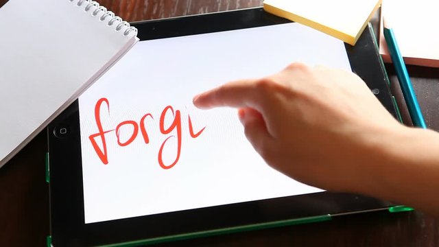 Forgiveness - hand write word on tablet