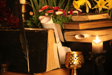 Antique Magic Book. Witchcraft Peacock feathers and candle background. Black candle Magic Ritual.