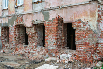 Fototapeta na wymiar The destroyed wall of a brick house