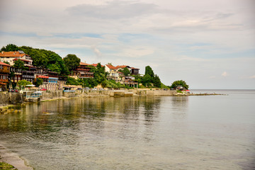 Obraz premium View of the seaside promenade with small cozy houses and water Bulgaria old Nessebar