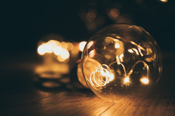 Light bulb with blurry background on dark brown wood table