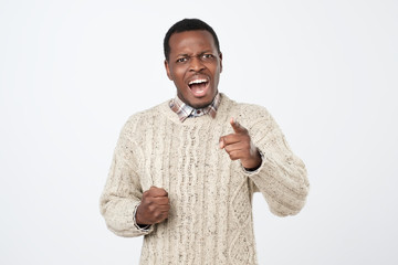 Disturbed displeased african man gestures angrily, has irritated expression, exclaims in despair.