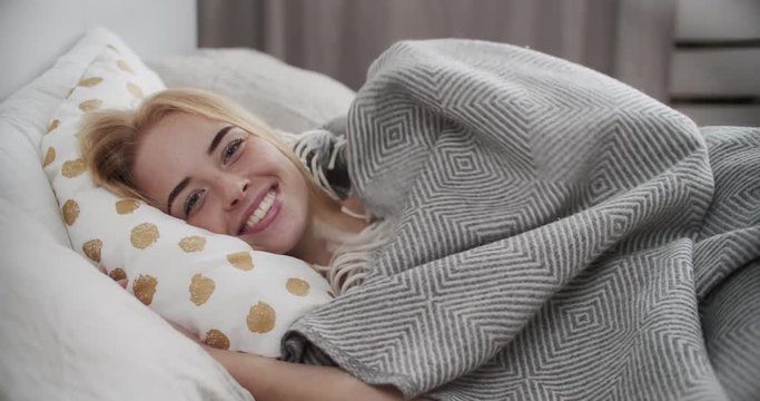 Woman hiding under blanket