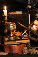 Black candle Magic Ritual. Antique Magic Book. Witchcraft  Peacock feathers and candle background.
