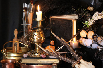 Black candle Magic Ritual. Antique Magic Book. Witchcraft  Peacock feathers and candle background.