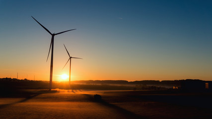 Obraz premium Windmill at Sunset . Wind turbines farm . 