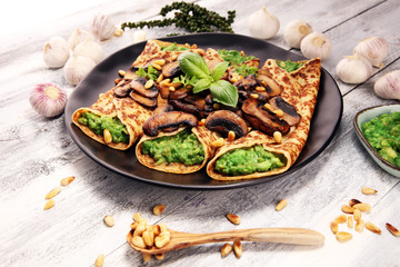 Savory Homemade Mushroom and Spinach Crepes with Cheese and avocado.