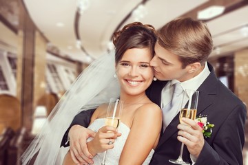 Young Wedding Couple Bride and Groom holding champagne glasses