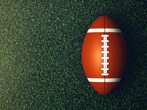 American football ball on grass lit by spotlight seen from the top, Game night background