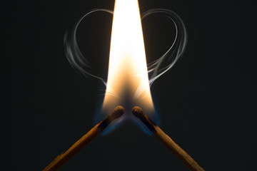 Fire from matches on a dark background. The concept of support and love.