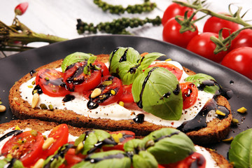 Bread with cream cheese and tomato for lunch table. Sharing antipasti on party or summer picnic time over wooden rustic background