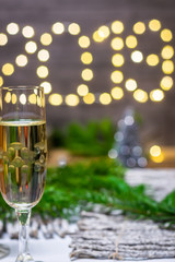 Moody new year decoration concept-glass of champagne on blurred new year background.