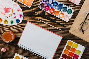 Flatlay of various stationery supplies knolled together on wooden table