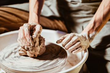 Artisan potter prepares material clay for pottery. Man knead clay before molding. Male sculptor is...