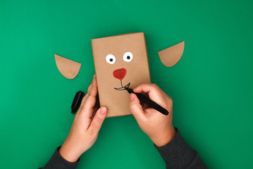 The original design of a Christmas gift from craft paper in the form of a deer on a green...