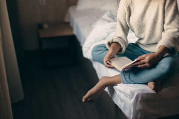 Girl reading a book in bedroom