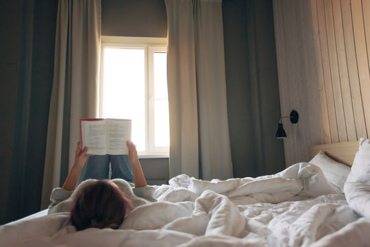 Girl reading a book in bedroom