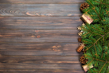 Christmas background with fir tree and gift box on wooden table. Top view with copy space for your design