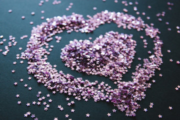 small loose glitter in the form of stars, glitter in the form of hearts, love background