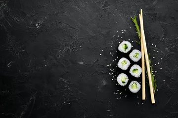 Selbstklebende Fototapeten Vegetarische Sushi-Rolle mit Gurke. Japanische Küche. Ansicht von oben. © Yaruniv-Studio