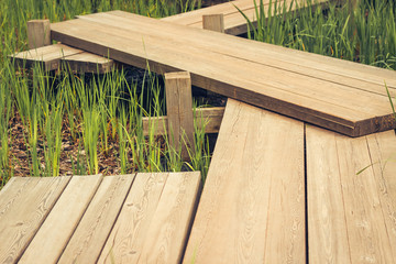 wooden bridge zigzagging a pond in Japanese garden
