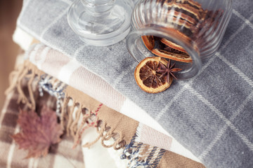 Blankets close up. Autumn cozy interior. A stack of warm blankets lie on a wooden chair. Autumn. Winter.