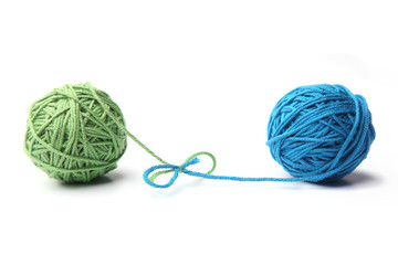 Two green and blue cotton thread balls tied in bow isolated on white background.  Different color...