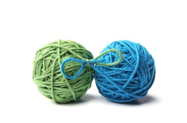 Two green and blue cotton thread balls tied in bow isolated on white background.  Different color...