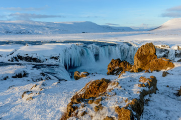 Frozen Godafoss waterfall on cold winters day at dawn, Northern Iceland