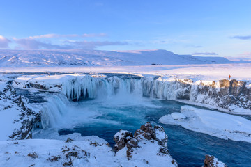 Frozen Godafoss waterfall on cold winters day at dawn, Northern Iceland