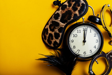 Sex time concept. Black alarm clock with sex toys.