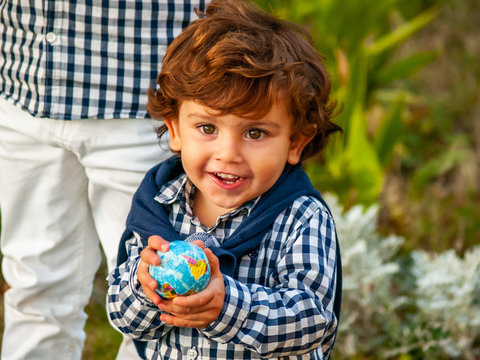 A child with a ball of the world or planet Earth in his hands. Ecology concept