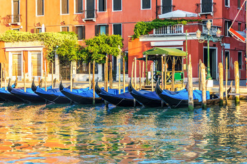 Fototapeta na wymiar Traditional gondolas by the pier in the channel of Venice