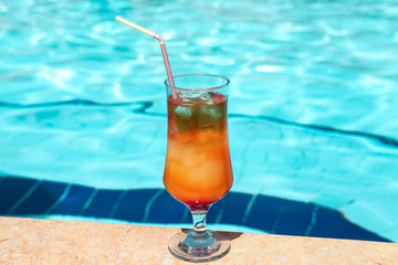Delicious cocktail Sex on the Beach on the pool background.