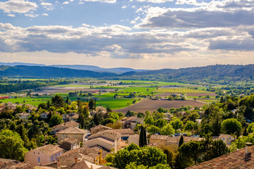 Fototapeta na wymiar Vue panoramique depuis la hauteur du village de Gréoux-les-Bains. Ciel bleu avec de baux nuages.
