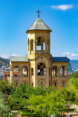 Beautiful view to chapel on site to Sameba Cathedral Tsminda in Tbilisi Holy Trinity . Biggest church Orthodox in Caucasus Georgia region in a sanny day. The main cathedral of the Georgian Orthodoxy