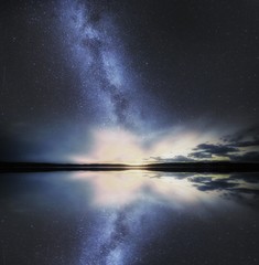 Dreamy surreal landscape with starry night sky and man silhouette