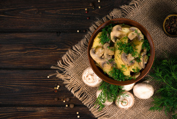 Fototapeta na wymiar potatoes with mushrooms on a wooden background