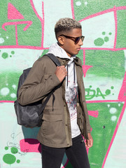 Joven de color con pared de graffiti
