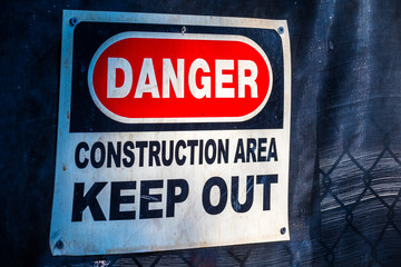 "Danger Construction Area Keep Out" sign posted on a fence at a construction site