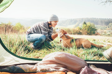 Woman and her dog tender scene near the camping tent. Active leisure, traveling with pet6 simple...