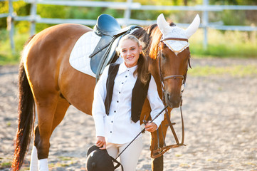 Girl equestrian rider stands near the horse. Horse farm. Horse theme  