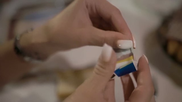 Closeup view of female hands opening gum